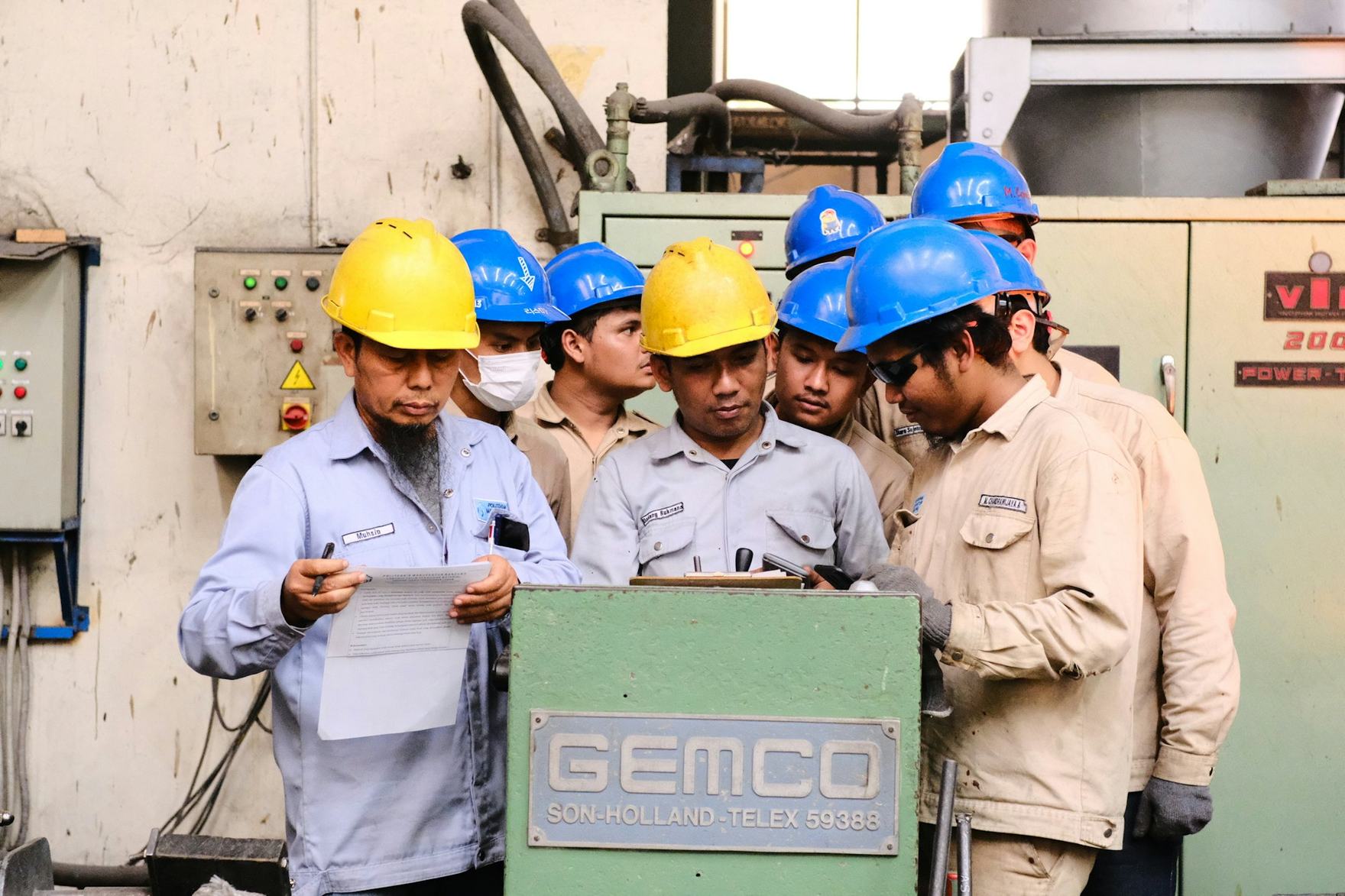Group of technicians in protective equipment reviewing documentation together